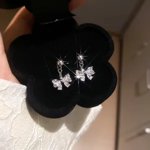 Bow-knot silver earrings with sparkling zircon stones in a black flower jewelry box