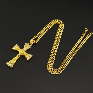 Detailansicht der goldenen Hip-Hop-Kreuzkette mit Kristallen und grober Panzerkette