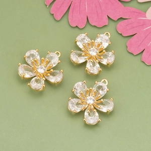 18k gold plated five-petal flower pendants with white zircon stones on green background
