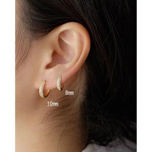 Detail of 18K gold huggie earrings with pavé zircons in 8mm and 10mm inner diameter sizes