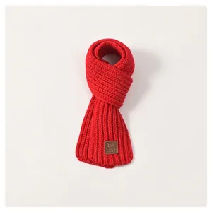Soft bright red knitted winter scarf for kids featuring classic thick weave and leather tag