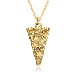 Macro shot of gold-plated planet pendant with irregular texture and cubic zirconia crystals