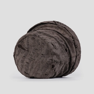 Close-up of dark brown distressed fabric with ripped hole detailing on the bucket hat