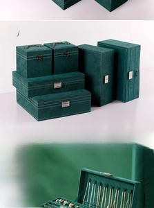 Detail view of emerald green suede jewelry boxes with metal locks and velvet lining