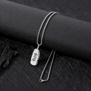 Vue macro d'un pendentif punk argenté avec mantra tibétain embossé sur métal poli