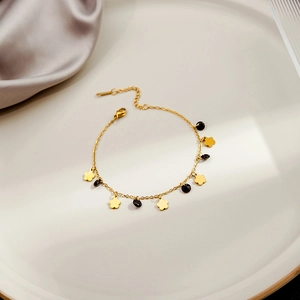 Minimalist gold heart and black bead bracelet with lobster clasp on a luxury tray
