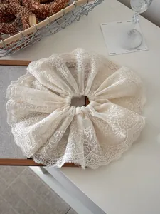 Detail of elegant double-layered lace scrunchie with delicate floral embroidery
