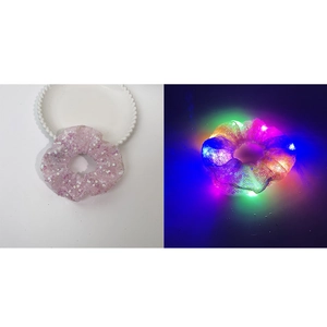Detailed comparison of pink sequin LED scrunchie in daylight and glowing in the dark
