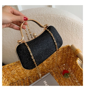 Detail of black sequin evening bag with gold metal handle and rhinestone sphere clasp
