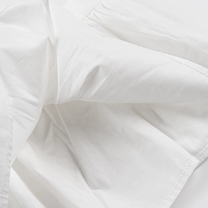 Détail macro du tissu en coton blanc et des coutures sur le haut à manches bouffantes