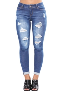 Détails rapprochés des déchirures et de l'effet délavé sur le jean skinny bleu