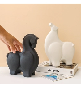 Close-up of matte ceramic horse statues showing smooth abstract lines and sandy texture