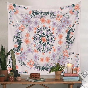 Detail shot of a bohemian mandala tapestry in vibrant pink and orange hanging on a wall