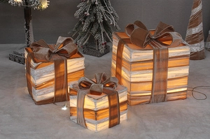Detailed view of three glowing champagne gold Christmas gift boxes with velvet bows