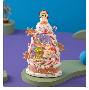 Macro detail of gingerbread tree snow globe with Santa Claus and festive candy motifs
