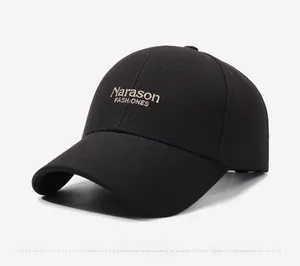 Close-up of beige Narason FASHIONES embroidery on a black cotton twill baseball cap