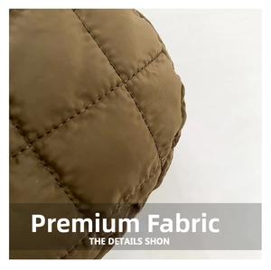 Detailed macro view of olive green quilted nylon fabric with puffy diamond stitching pattern