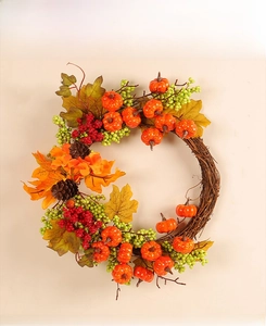 Detailed view of autumn wreath with orange pumpkins, maple leaves, and pine cones