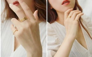 Detailed view of layered minimalist gold titanium steel rings worn by a model