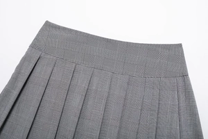 Vue détaillée de la taille à boucle et des plis gris à carreaux sur la mini-jupe