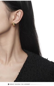 Close-up of minimalist irregular gold curved earrings worn on model for a sleek look