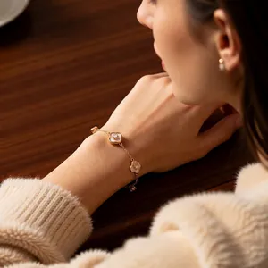 Bracelet trèfle plaqué or 18 carats avec nacre blanche et zircon au poignet du mannequin