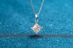 Detailed view of square princess cut moissanite pendant on a silver chain with starry background