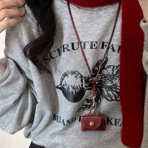 Retro burgundy leather mini neck pouch for earphones and coins on a casual sweater
