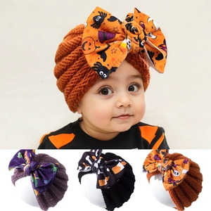 Detail showing baby Halloween knitted headbands with large bows in festive patterns