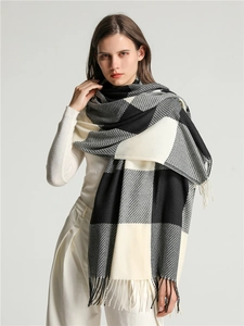 Close-up of thick checkered scarf with gray fringe tassels on model shoulder