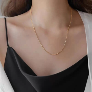 Elegant gold snake bone chain necklace in titanium steel worn on a female neck model
