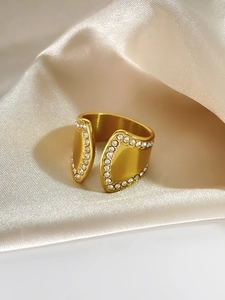 Detail eines 18K vergoldeten Rings mit doppelreihigen Steinen auf Seidenstoff