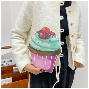 Detail of creative cupcake shaped crossbody bag with cherry top and glitter PU finish