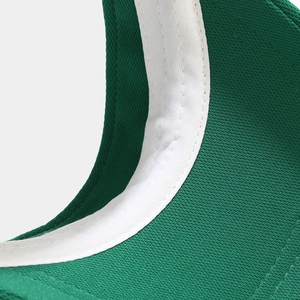 Détail de la visière verte montrant les coutures de la bande et le tissu maille aéré