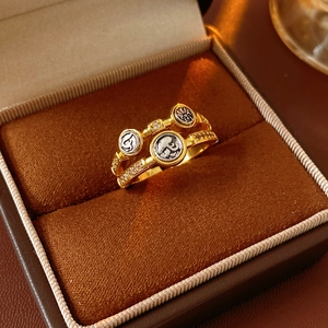 Détail d'une bague vintage dorée avec zircons et médaillons sur boîte en velours