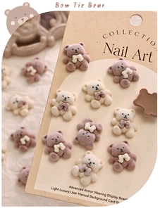 Detailed view of 3D flocked nail art bears in brown and cream colors with bow ties