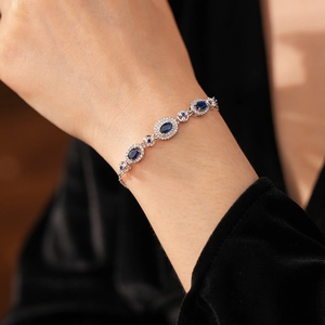Macro detail of vintage oval blue sapphire bracelet with silver settings on wrist