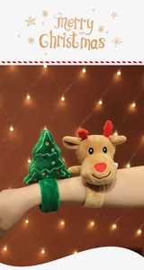 Detail of plush Christmas snap bracelets featuring reindeer and tree on wrist with bokeh lights