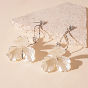 Elegant floral pearl earrings with cubic zirconia set on natural stone background