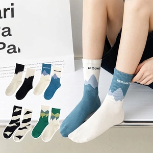 Asymmetrical mountain pattern crew socks in blue, green, and black for men and women