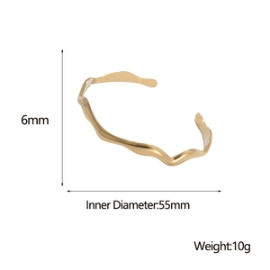 Detail showing wave design gold bangle with 6mm width and 55mm inner diameter