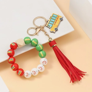Detail of colorful school bus keychain with wooden bus pendant and decorative leather tassel