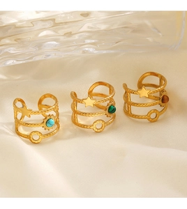 Macro shot of bohemian gold rings with star relief and colorful inlaid natural stones