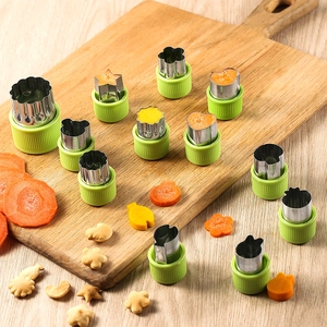 12pcs stainless steel fruit and vegetable cutters with green handles on wooden board