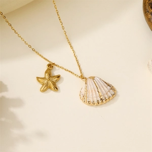 Detail of golden starfish and white seashell pendant on a delicate summer beach necklace