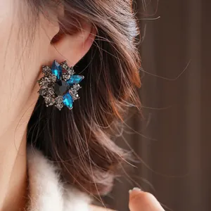 Vintage crystal flower stud earrings featuring navy blue petals and black center stone