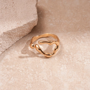 Detail of irregular golden lava ring with metallic luster on stone background