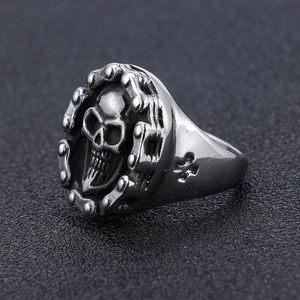 Detail shot of vintage silver skull ring with chain texture and cross engraving on side
