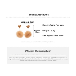 Detail view of heart-shaped leopard print earrings with fluffy pompom pendants