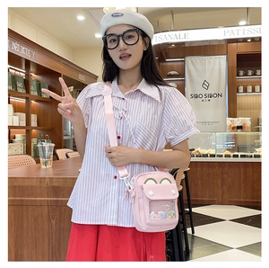 Close-up of pink ita bag with transparent window and cute frog eyes on the flap